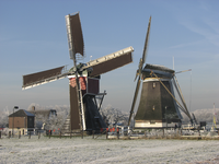 901062 Gezicht op de beide molens bij de Nedereindsevaart te Oud-Zuilen (gemeente Maarssen), in een winters landschap.